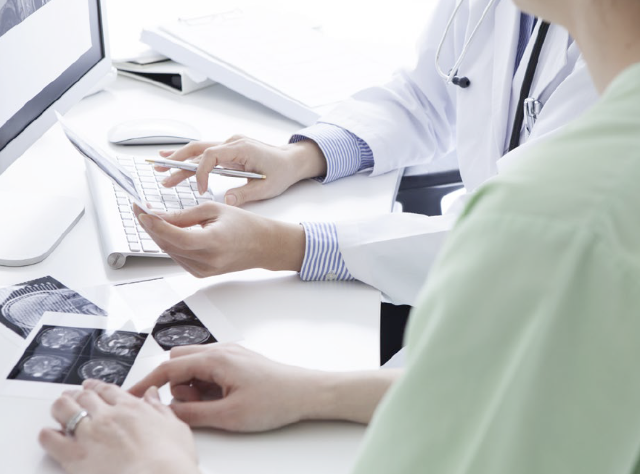 Læge og patient ser på scanningsbilleder